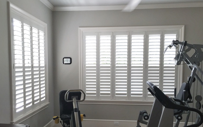 Austin home gym with shuttered windows.